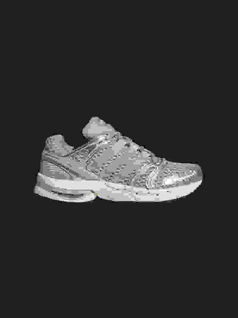 A pair of gray and white athletic shoes with a textured pattern on the surface, set against a dark, cracked background.