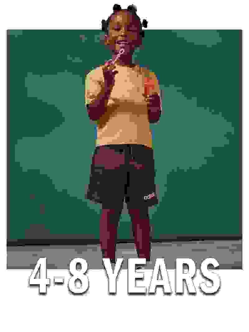 A young child, with braided hair, wearing a yellow shirt and brown shorts, is smiling and holding a popsicle against a teal background with the text "4-8 YEARS" displayed.