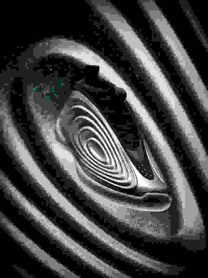 A futuristic-looking shoe with a sleek, curved design sits against a swirling, cosmic-like background filled with shimmering particles.