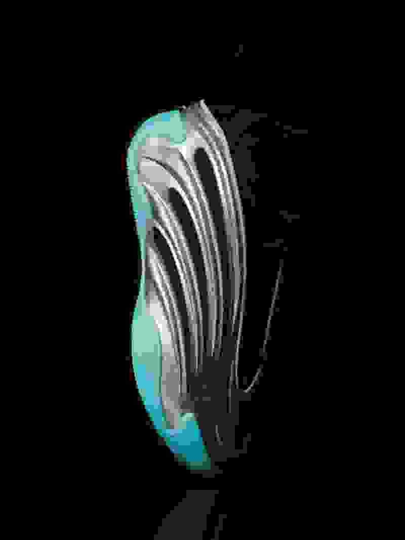 A sleek, futuristic-looking shoe with a striking teal and silver color scheme against a dark background.