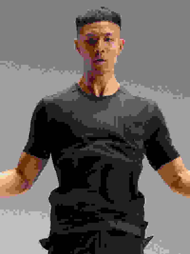 Man wearing adidas training t-shirt jumps over skipping rope.