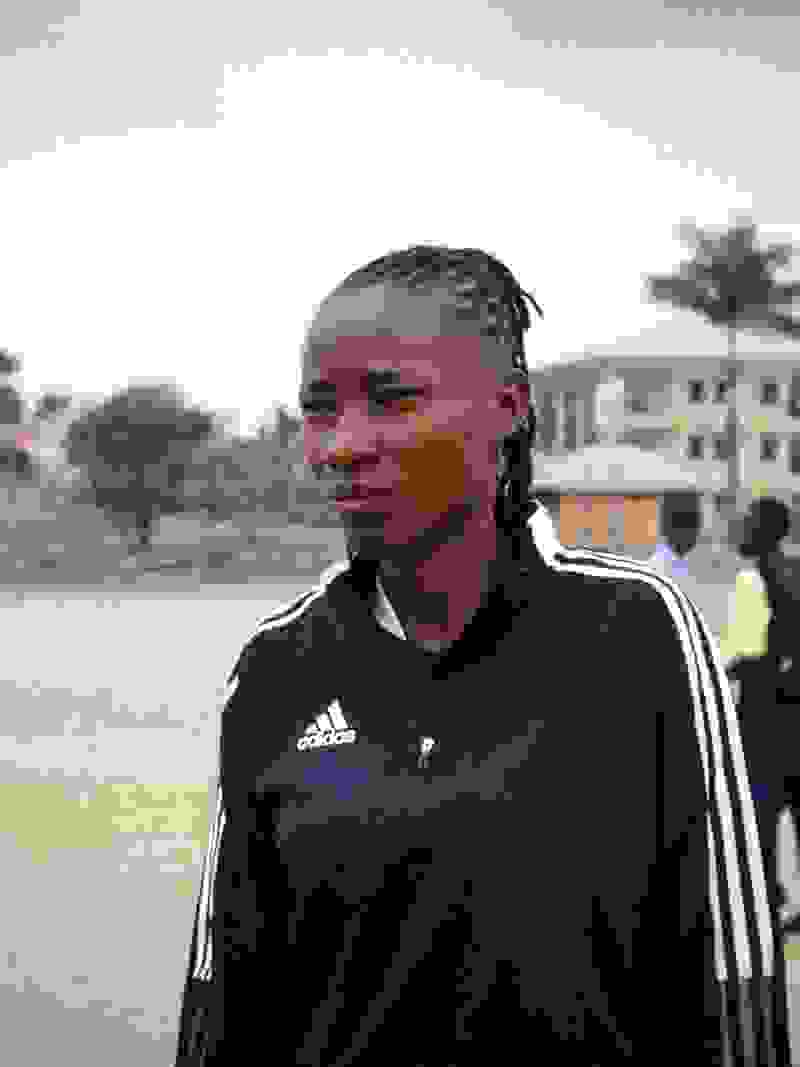 A girl in adidas tracksuit in front of a building