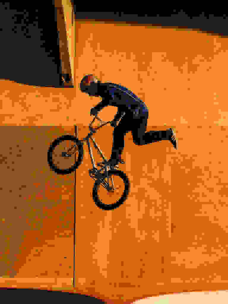 Olympian Kieran Reilly doing a BMX trick, wearing adidas.