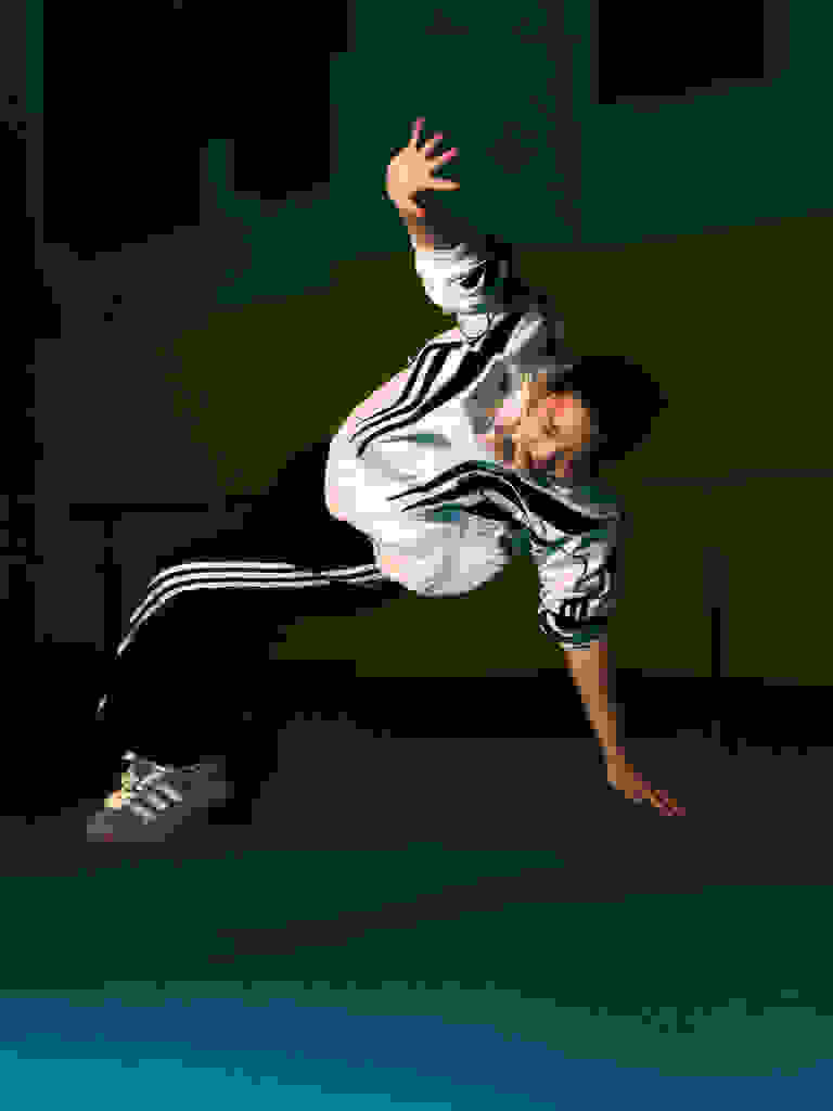 Olympian B-Girl 671 breakdancing, wearing adidas.