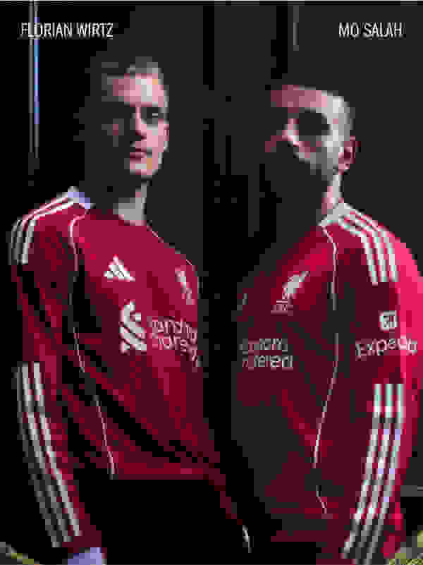 Two soccer players wearing Liverpool FC jerseys stand in a dark background.