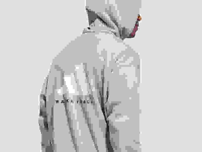 Un sweat-shirt à capuche beige avec le mot "Basketball" imprimé dans le dos, sur un fond blanc uni.