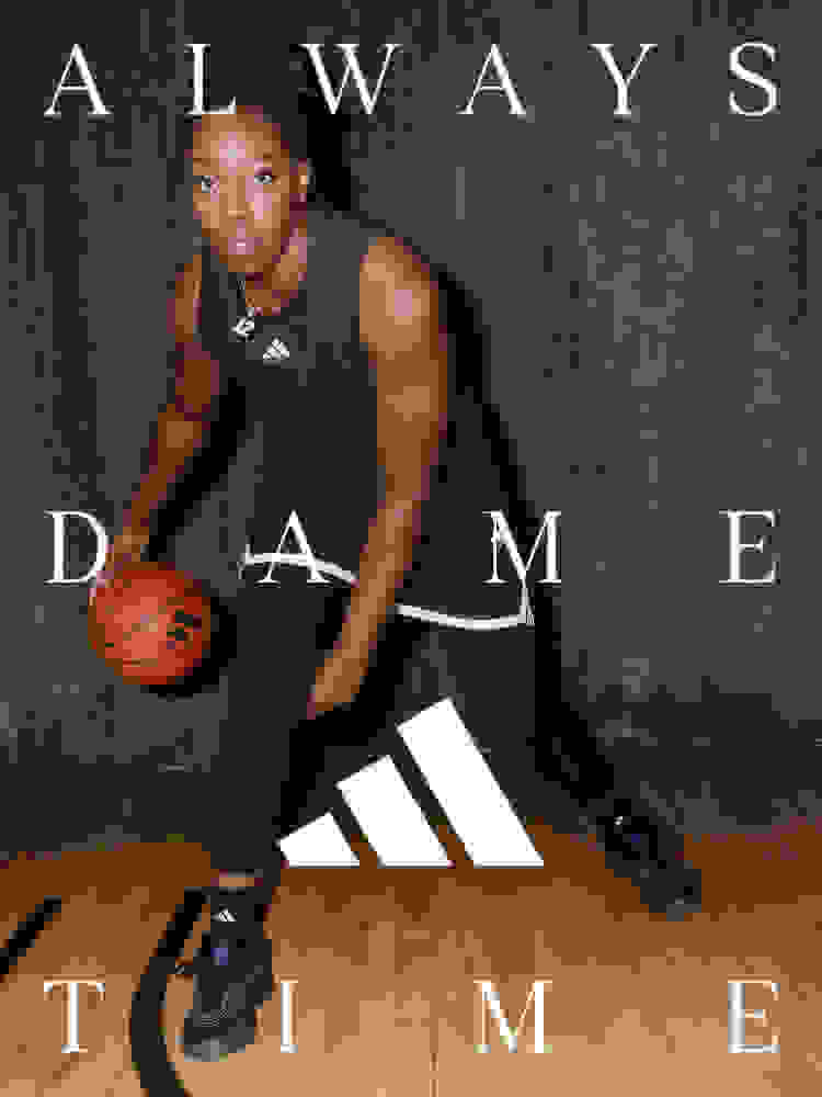 A young athlete in a basketball uniform stands on a basketball court, holding a basketball and posing for the camera.