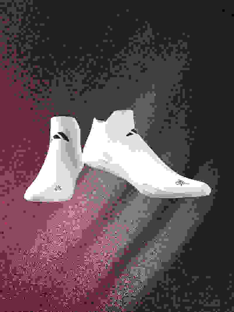 A pair of white athletic shoes with black accents are suspended against a dark, textured background with a reddish hue.