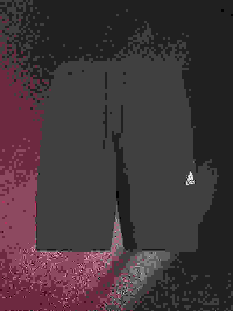 Navy blue Adidas athletic shorts on a dark, textured background.