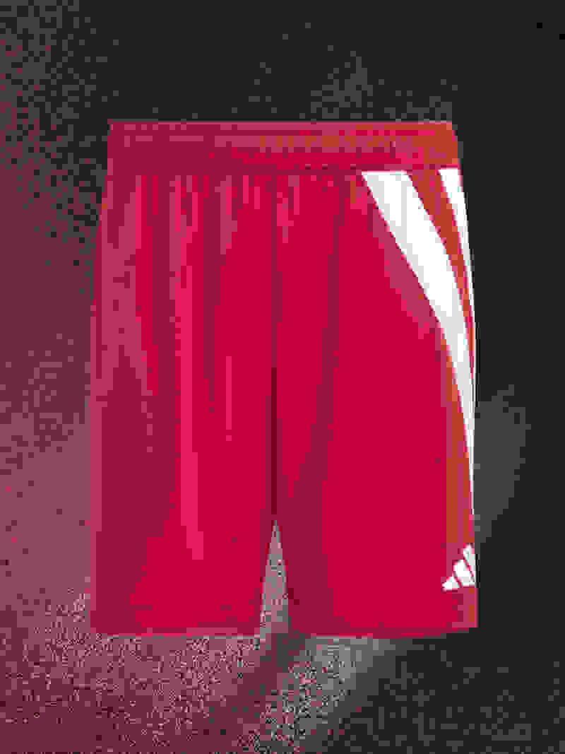 A pair of bright red athletic shorts with white stripes on a dark background.