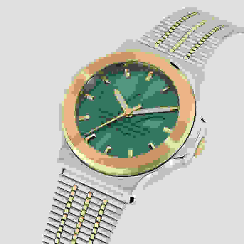 A silver and gold-toned wristwatch with a green dial and a stainless steel bracelet.