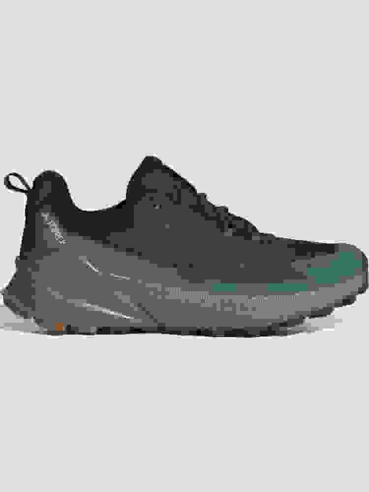 A pair of black and teal athletic shoes with a thick, textured sole sits on a plain white background.