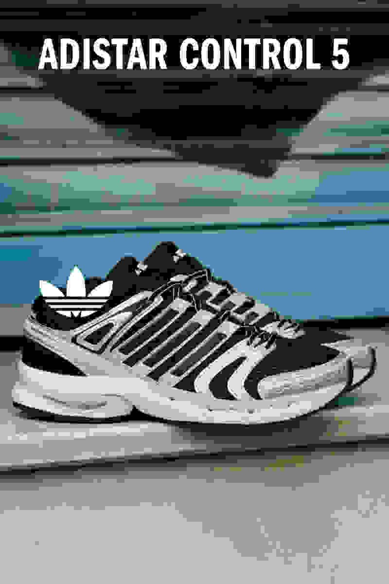 The image shows a pair of black and white Adidas Adistar Control 5 running shoes on a wooden surface, with the Adistar Control 5 branding visible on the shoes.