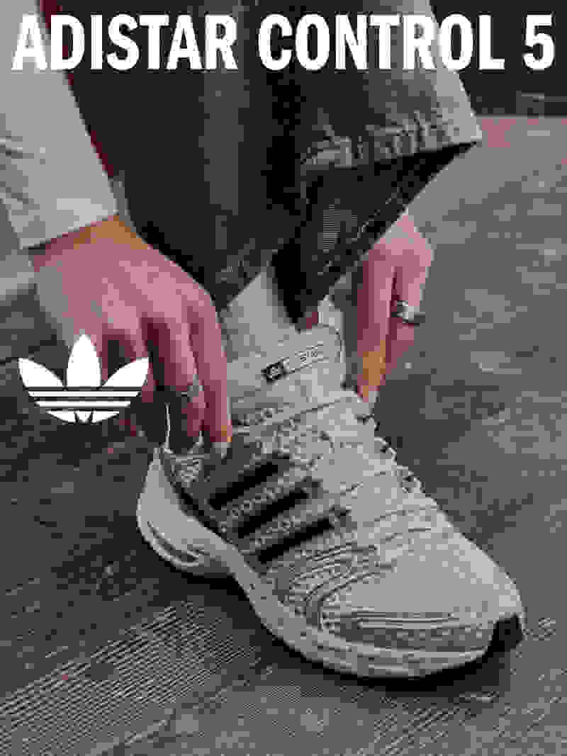 The image shows a close-up view of a person's feet wearing a pair of gray and white Adidas Control 5 sneakers, standing on a wooden surface.