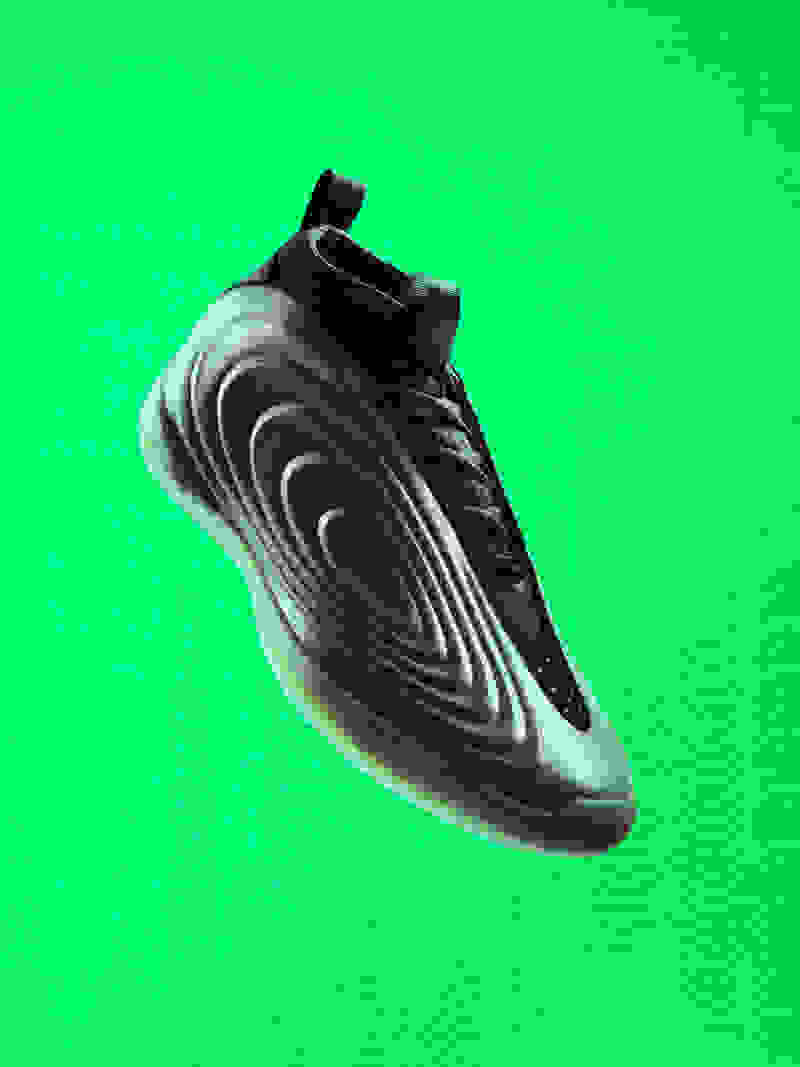 A black, futuristic-looking shoe with a wavy, undulating design floats against a vibrant green background.