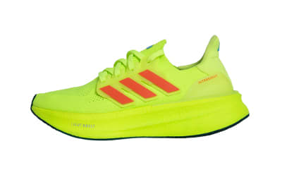 A bright neon green athletic shoe with red accents sits on a plain white background.