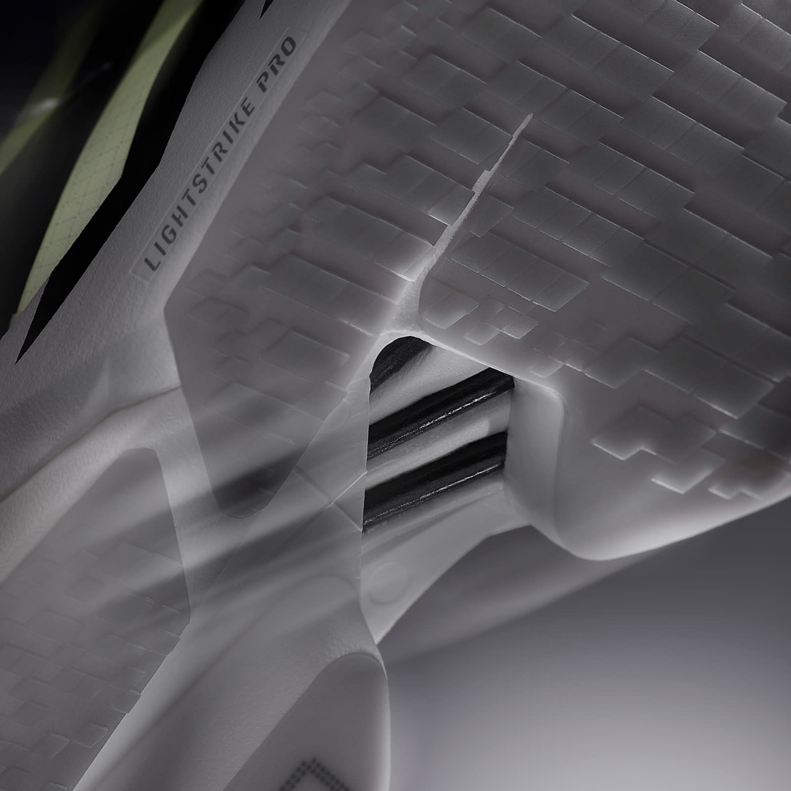 The image depicts a close-up view of a complex, abstract geometric structure with intricate patterns and shadows, creating a visually striking and textured composition.