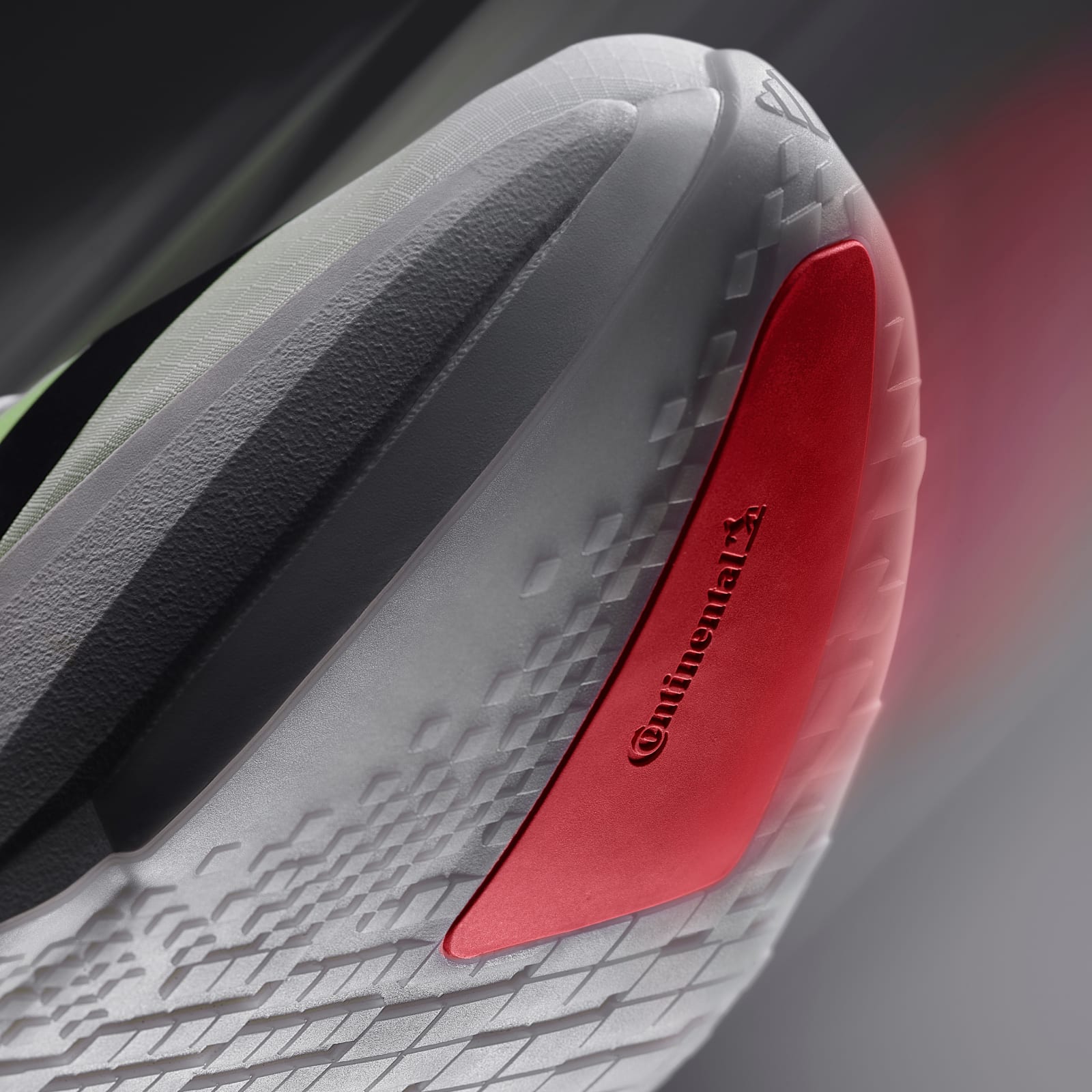 A close-up view of a white and red athletic shoe, with a textured sole and a prominent red logo on the side.