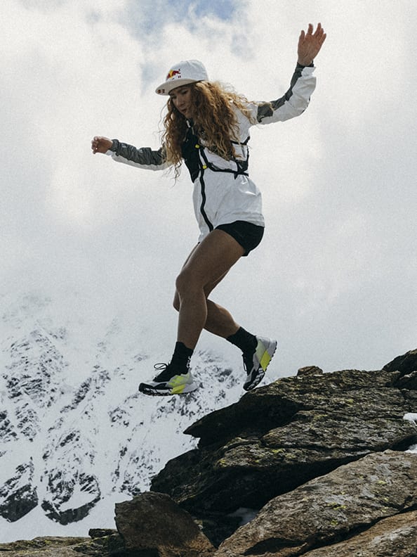 Athlete Ekaterina wearing the Agravic Ultra running down rocky mountain trails