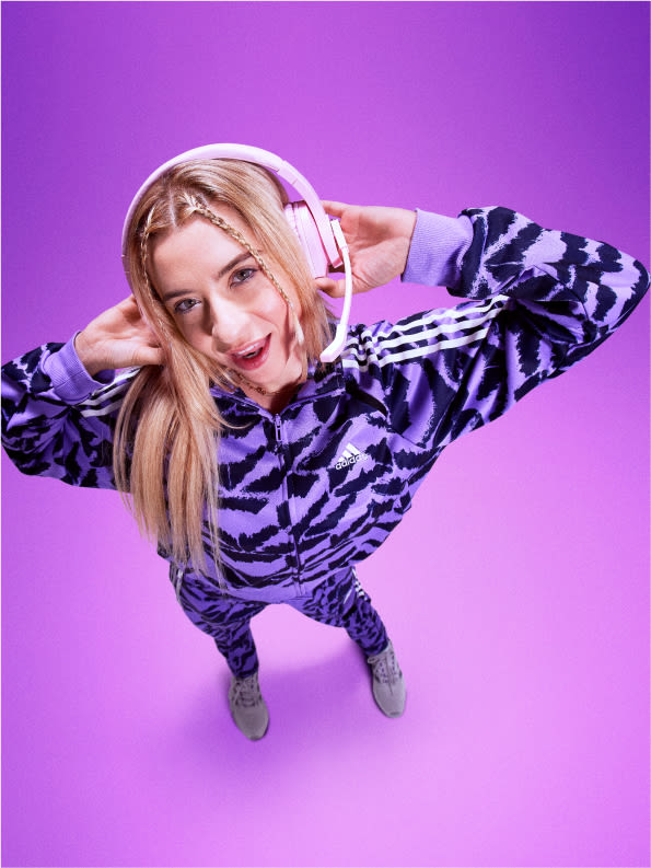 Pro gamer Carolina Voltan dressed in purple adidas track suit with gaming headphones on.