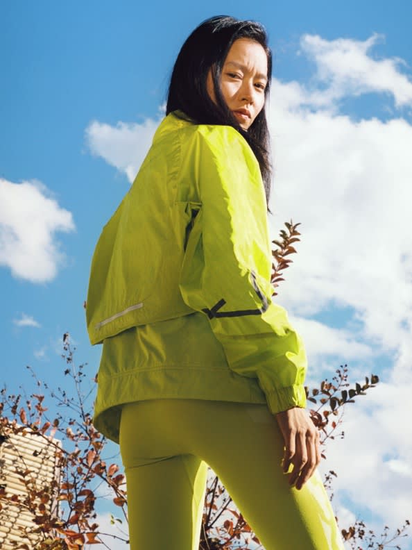 A collection of 3 images featuring the latest Workout Wardrobe drop from adidas by Stella McCartney.1. Leila Davis looks to camera wearing a white bra and pink leggings. 2. Nami Nagakura stands in all-yellow. 3. Leila Davis smiles wearing an all-grey look with a neon-accented bum bag.
