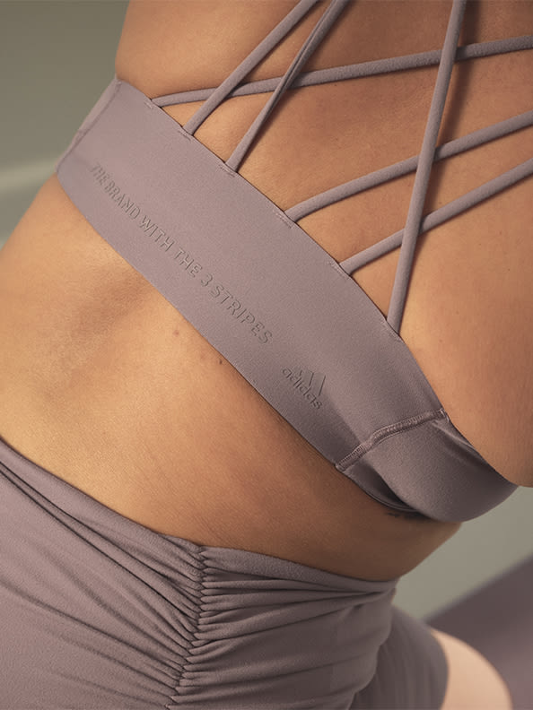 Image of the back of a model wearing lavender cross detailed bra and tights co-ord
