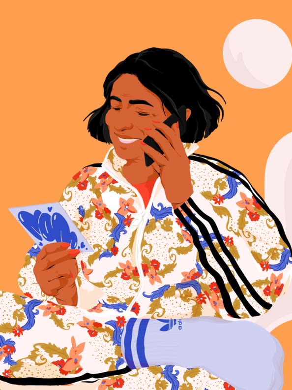 Mom talks to her daughter with her Mother’s Day card in hand wearing a new floral track top.
