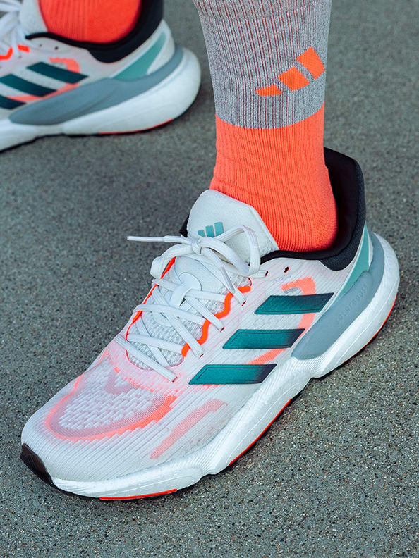 Image of white running shoes with blue stripes