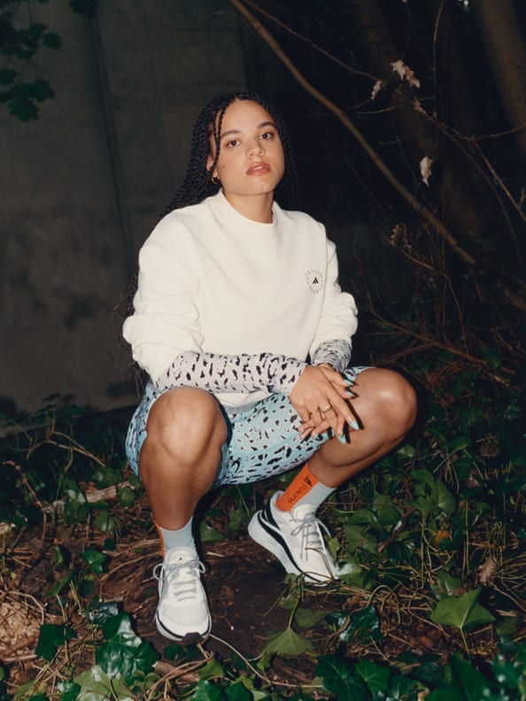 Izzy from community enterprise "Challenge our art system" wears key pieces from the adidas by Stella McCartney SS22 Pre-Season Capsule, including a sweater & short tights.