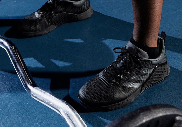 Model wears black adidas training shoes