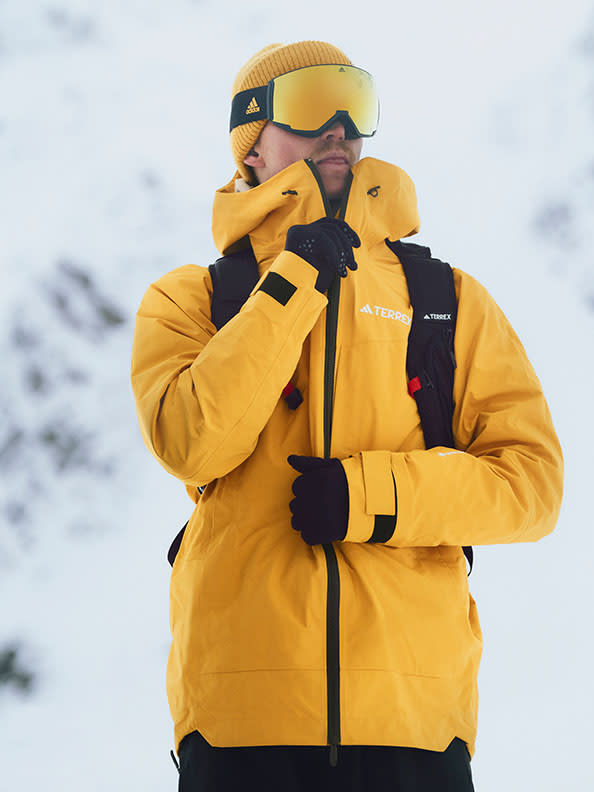 A person wearing a yellow jacket and goggles