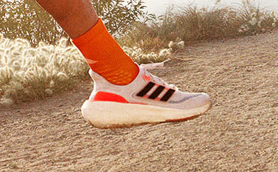 Image of foot running outdoors wearing Ultraboost Light.