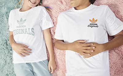 Two kids laying on the ground, wearing white t-shirts
