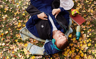 Man lying amongst Fall leaves.