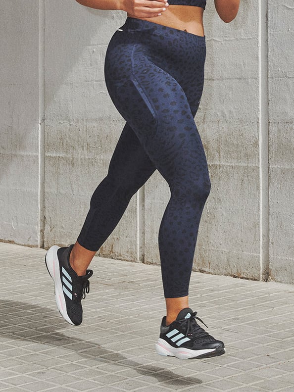 Image of a model jogging wearing navy-blue bra and tights co-ord