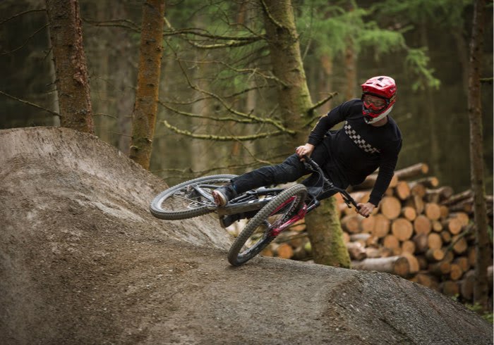 A man riding a bike in the forest.