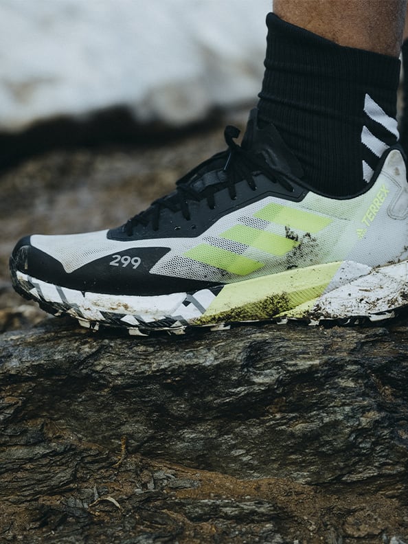 Athlete wearing the Agravic Ultra on muddy moutain trails