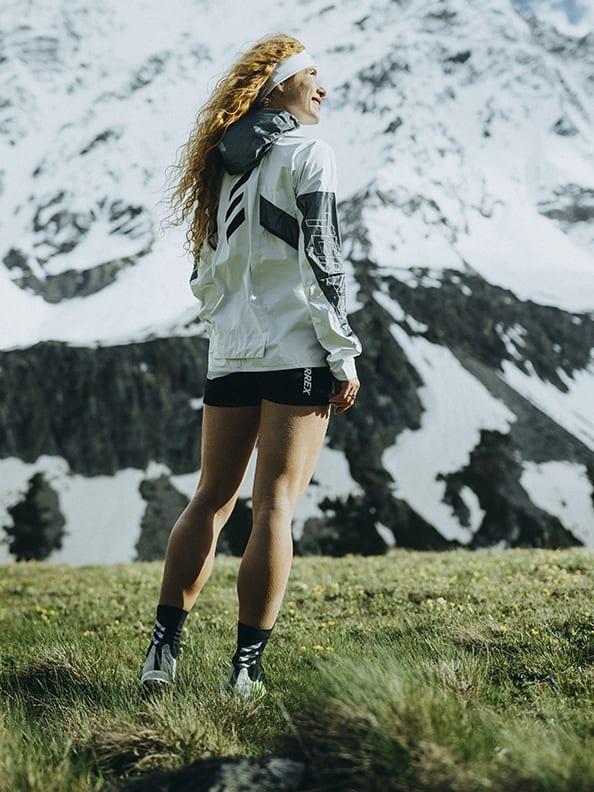 Athlete Ekaterina wearing the Agravic Ultra standing on trail in moutain landscape