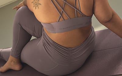 Image of the back of a model wearing lavender cross design bra and tights co-ord