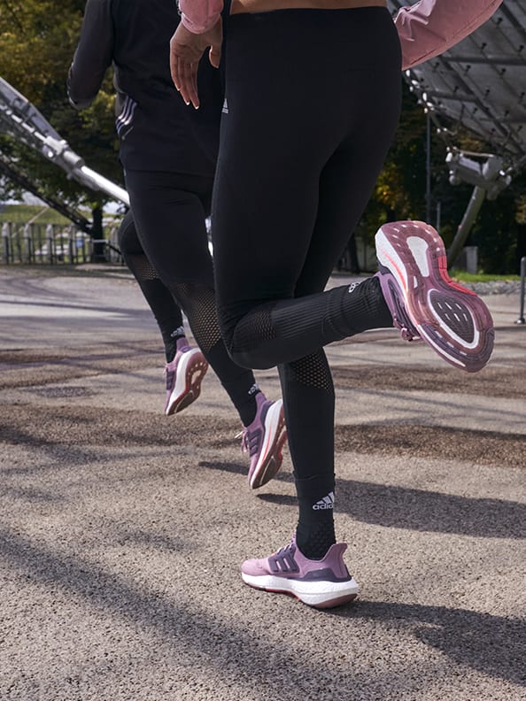 Close up of two people running with the new Ultraboost 22 running shoe