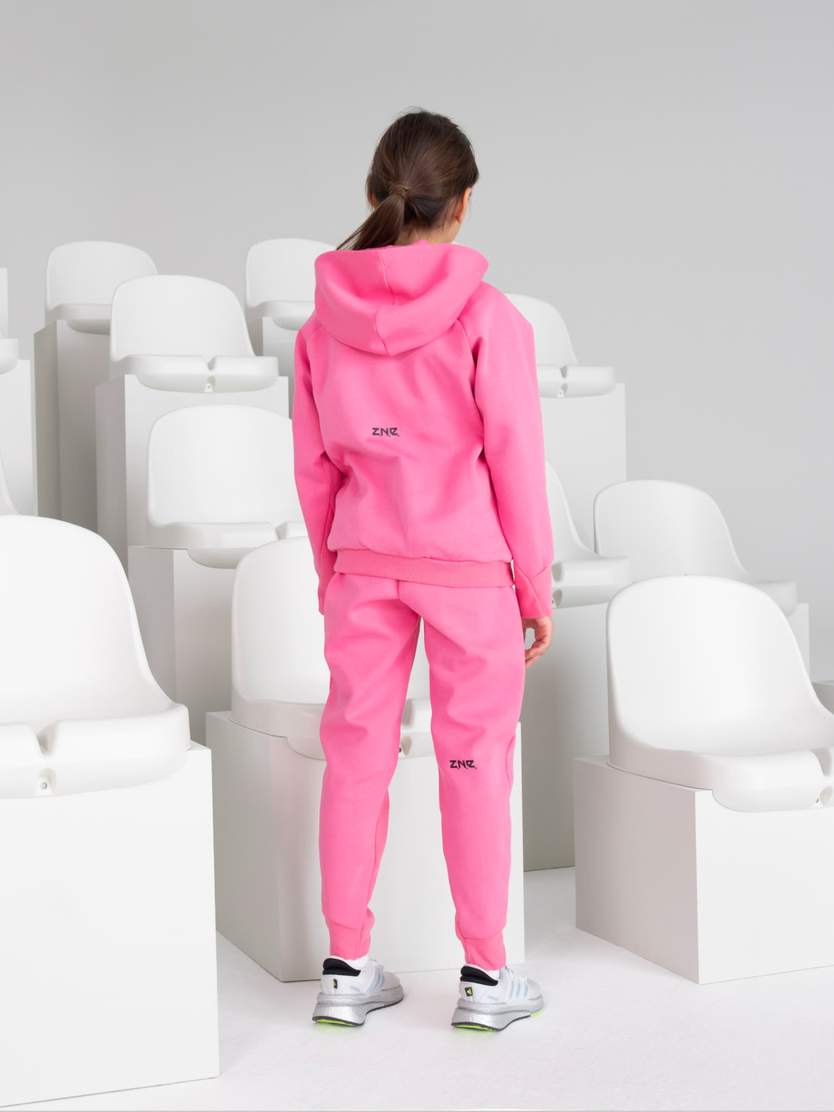 Child model wears Z.N.E. Sportswear hoodie, pictured from the back.