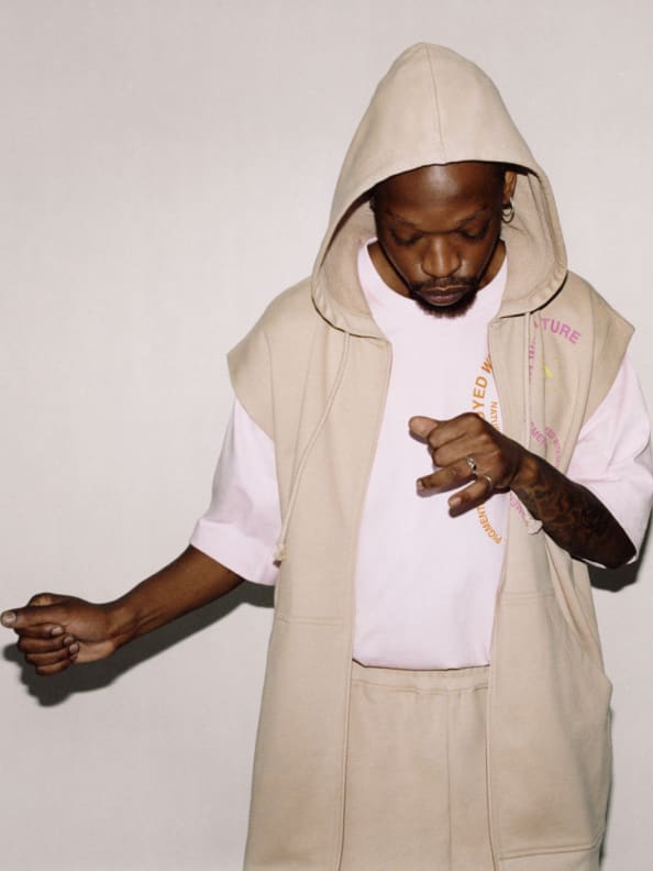 A male model wears the new sleeveless hoodie and sweat pants from the SS23 adidas by Stella McCartney gender-neutral loungewear drop. Crafted from 100% organic cotton.