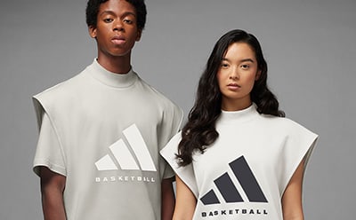 A man and woman standing beside each other in sleeveless adidas Basketball shirts