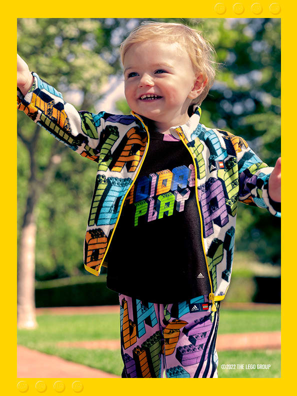 Smiling infant in multi-coloured top and bottoms