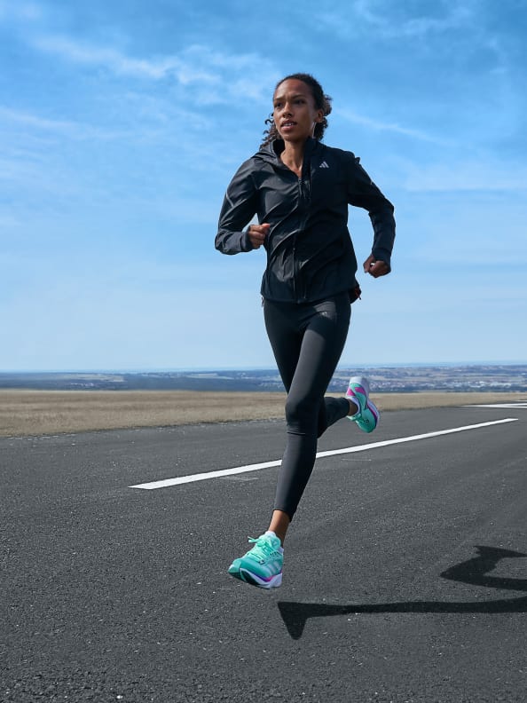 An image shows a a woman running in the sunshine in Adidas running apparel