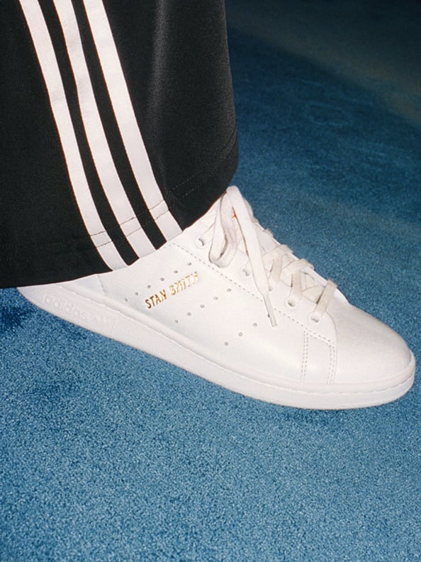 Close-up of a white Stan Smith shoe worn by a model.