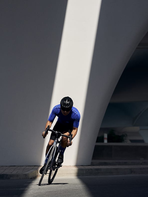 A MAN CYCLING IN A RAY OF SUNLIGHT