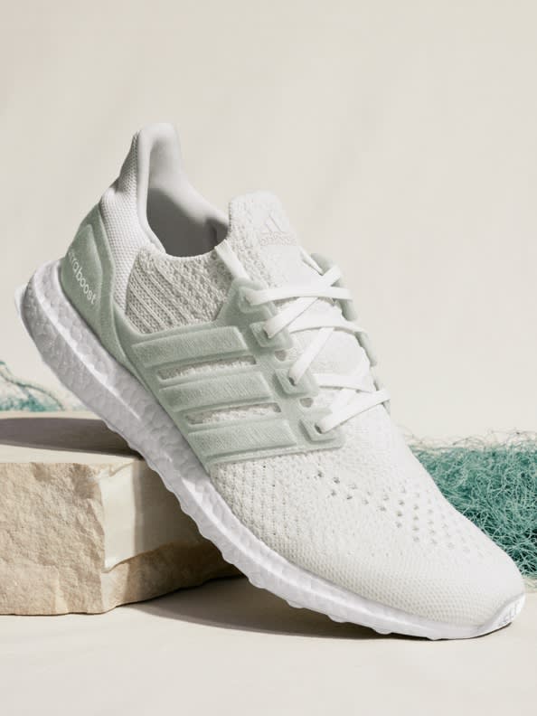 Pair of Ultraboosts with light background, one shoe on its side to show sole.