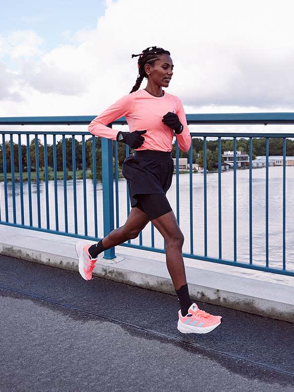 Side view of woman running with adidas Adistar running shoe