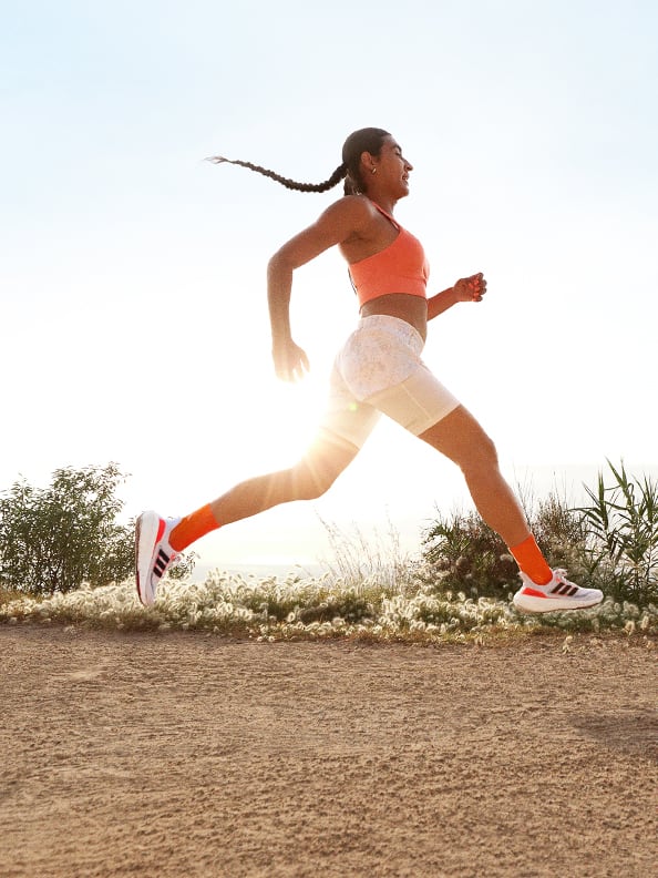 Image of woman running outdoors wearing Ultraboost Light shoes.